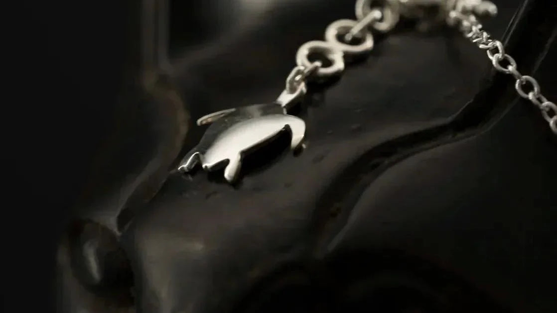 Pendentif tortue en argent massif 925 sur chaîne, gros plan fond noir | Honu