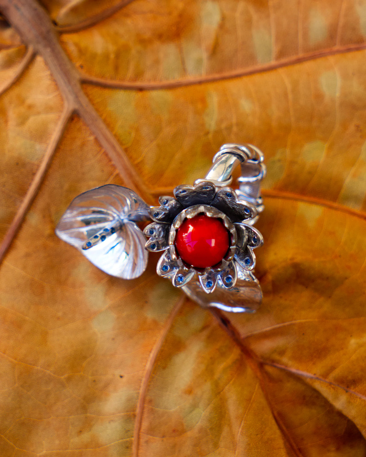 La bague Alice, argent massif 950 ‰ rhodié, perle de corail rouge de Méditerranée et saphirs bleus, de la collection Caprice | Honu