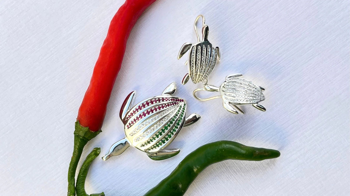 Le pendentif Totem Luth Italia, tsavorites, diamants et rubis sur argent massif, avec des boucles d'oreilles Totem Luth, vue en biais, format panoramique | Honu