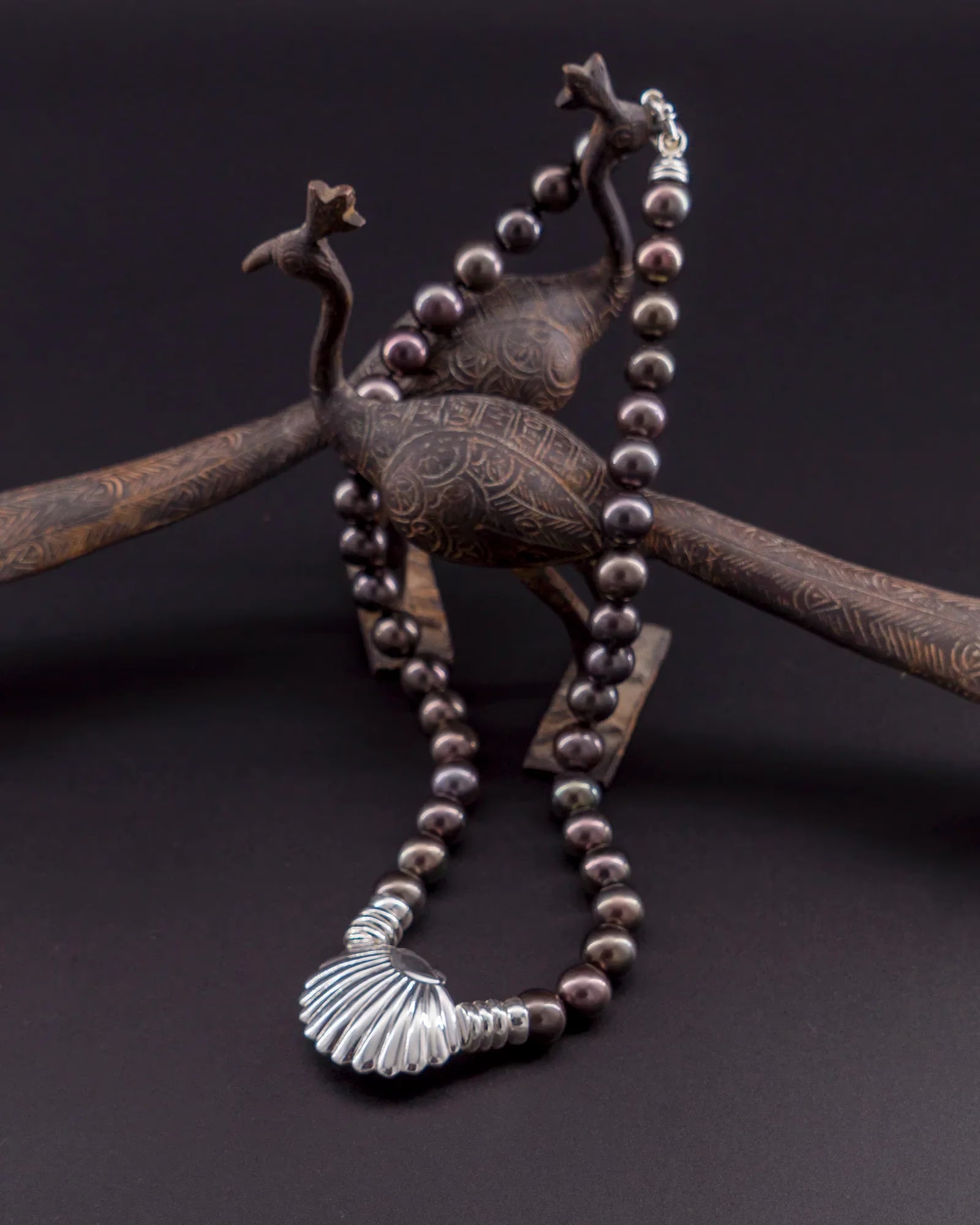 Tahitian pearl necklace with silver shell pendant on display stand | Honu
