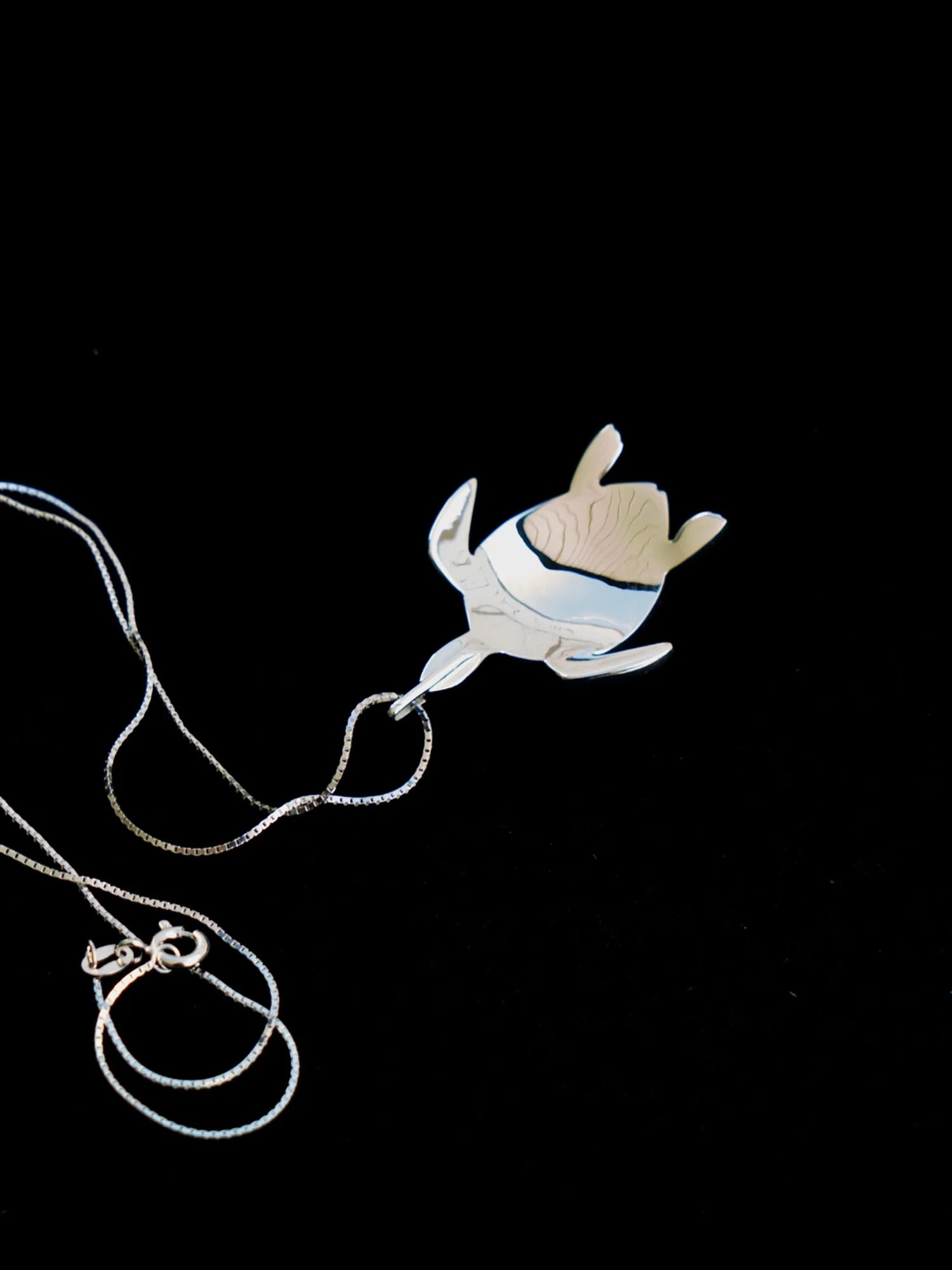 Le revers du pendentif Totem Luth, surface lisse et chaîne déposée, de la collection Totem Luth | Honu