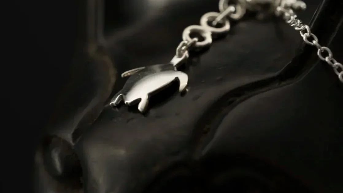 Pendentif tortue en argent massif 925 sur chaîne, gros plan fond noir | Honu