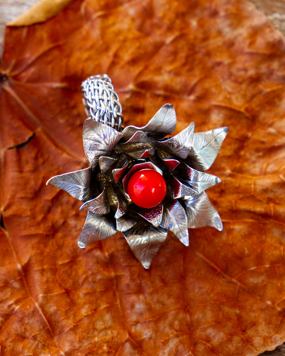 The Suzy ring, in solid silver 950‰ rhodium-plated, featuring a red Mediterranean coral pearl and blue topazes, from the Caprice collection | Honu