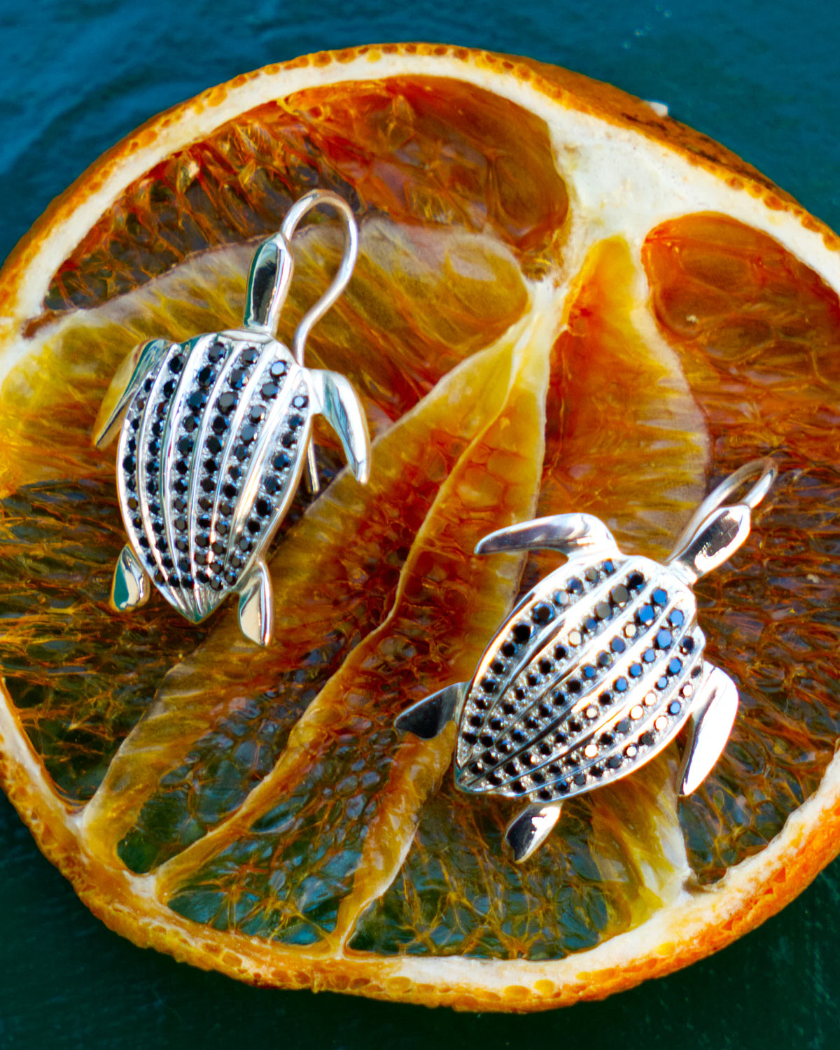 Les boucles d'oreilles Totem Luth, diamants noirs sur argent massif, en gros plan, le pavage de diamants noirs détaillé | Honu