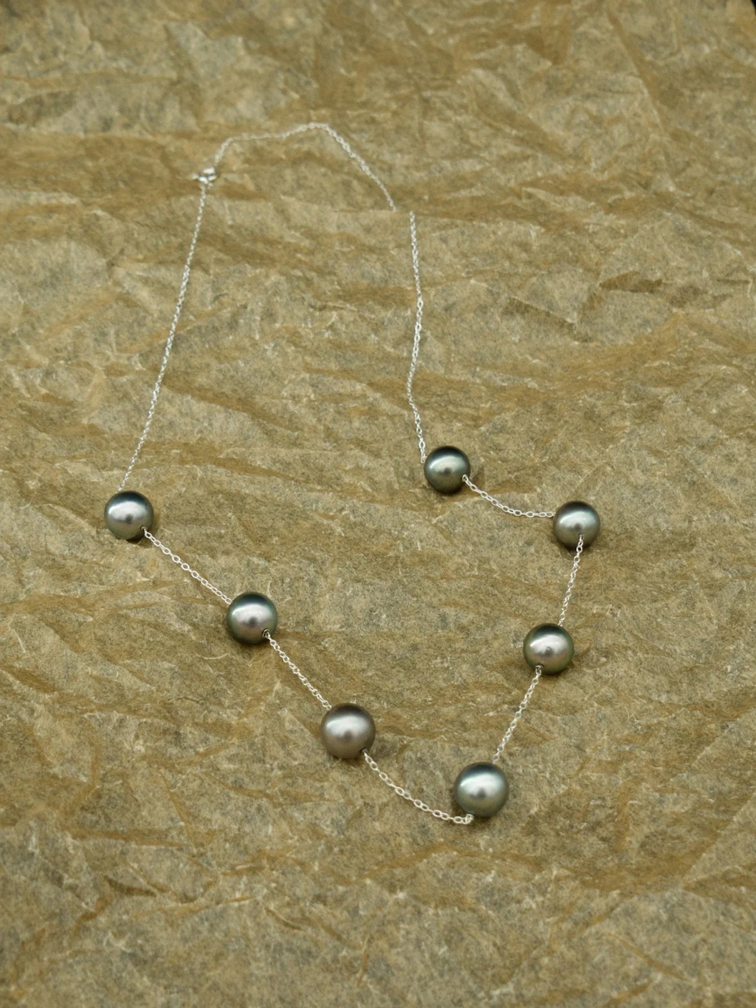 Le collier Émergence 21.98, ses sept perles de Tahiti réparties sur la chaîne, sur une pierre claire, de la collection Instinct | Honu