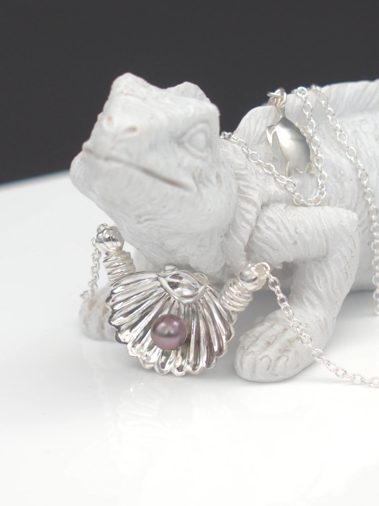 Collier argent massif 950 avec pendentif coquillage et perle de Tahiti foncée, et pendentif tortue, sur figurine.