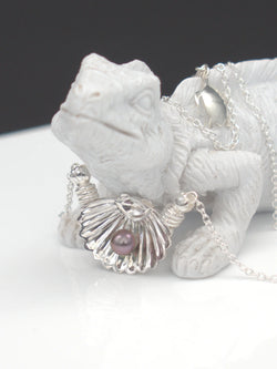 Collier argent massif 950 avec pendentif coquillage et perle de Tahiti foncée, et pendentif tortue, sur figurine.