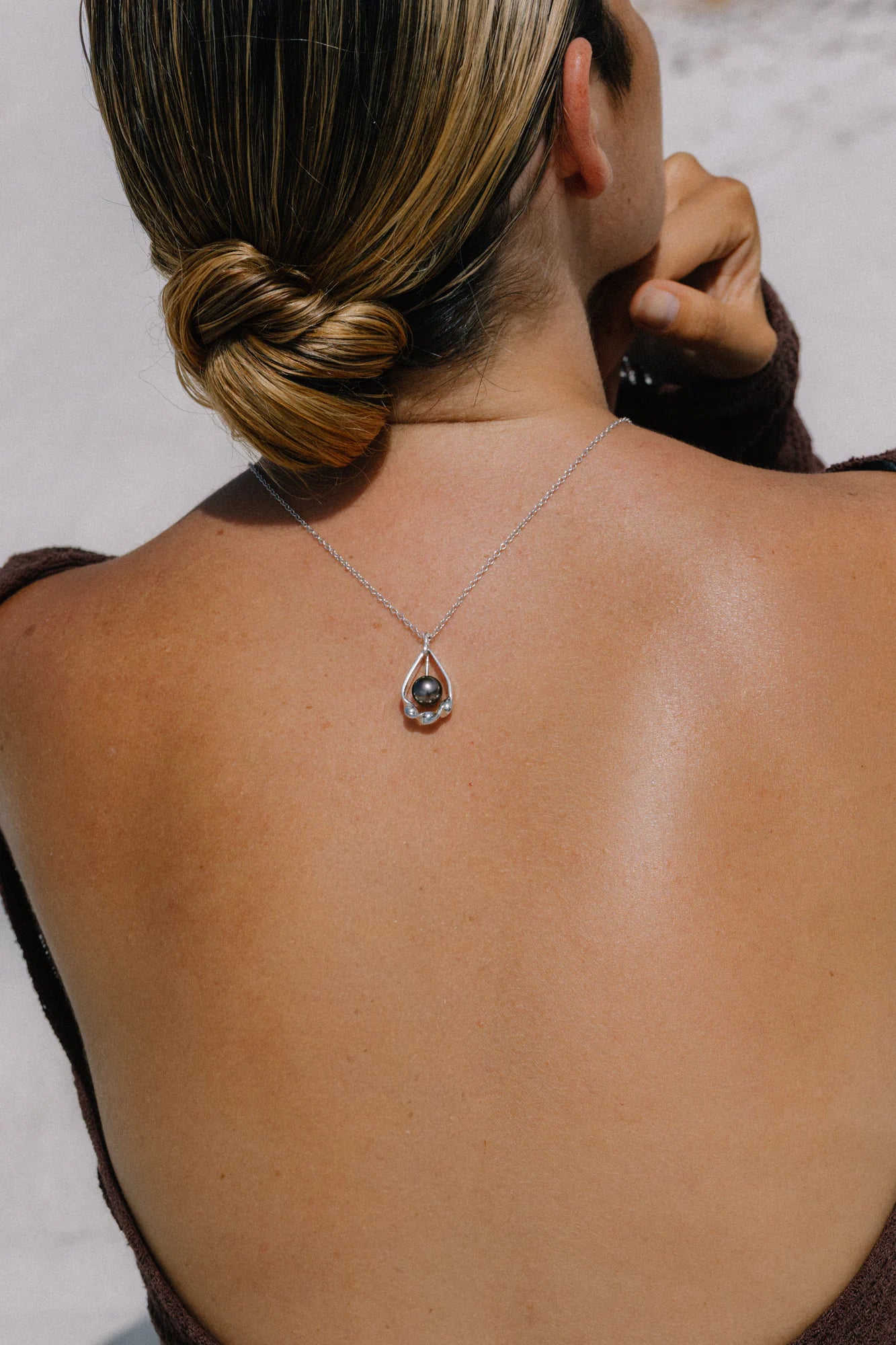 Pendentif TāMahana porté, de la collection Lagon, shooting Spring Summer 2026 | Honu