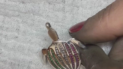 Le pendentif Totem Luth aux couleurs de l'Italie, pavé de tsavorites, de diamants et de rubis, tourné entre les doigts pour faire jouer la lumière, en hommage à la Milano Jewelry Week | Honu