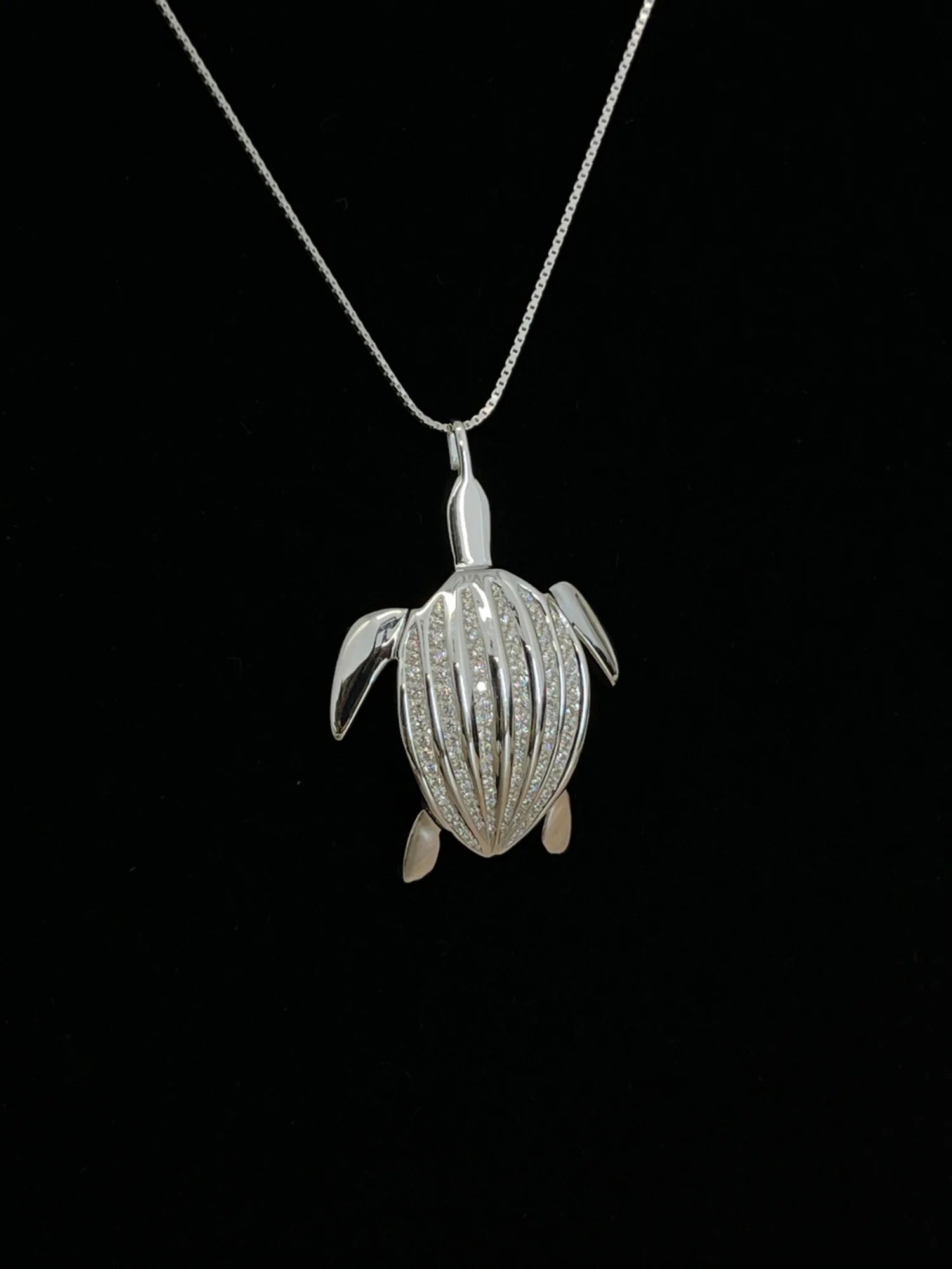 Le pendentif Totem Luth en gros plan sur sa chaîne, ses rangées de diamants, de la collection Totem Luth | Honu